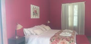 a bedroom with a large bed with purple walls at Posada del Olivo in Nonogasta