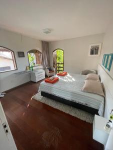 a bedroom with a large bed and wooden floors at Enjoy Hostel e Pousada in Aracaju