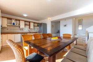 eine Küche und ein Esszimmer mit einem Holztisch und Stühlen in der Unterkunft vila ivan i ian in Stanići