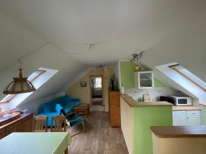 cocina y sala de estar con paredes verdes y blancas en Fewo Auszeit Schwanow, en Rheinsberg