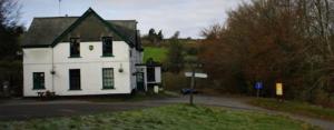 a white house with green shutters on a street at the Dartmoor bnb in Yelverton