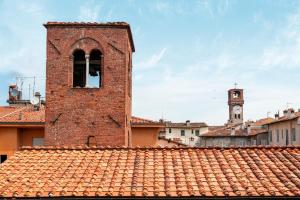 un edificio de ladrillo con una torre de reloj en una ciudad en Luxury Flat in Town - Lucca City Center, en Lucca