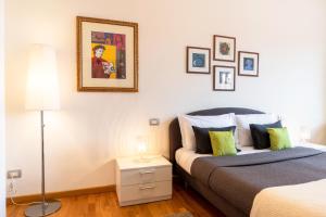 um quarto com uma cama e uma mesa com um candeeiro em Luxury Flat in Town - Lucca City Center em Lucca