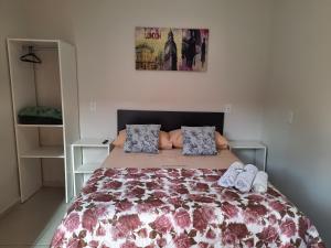 a bedroom with a bed with two pairs of shoes on it at Hotel Três Passos - Prox ao Aeroporto e Rodoviária in Porto Alegre