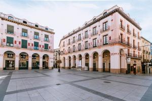 a large pink building with a courtyard in front at Capricho de Vidania in Huesca