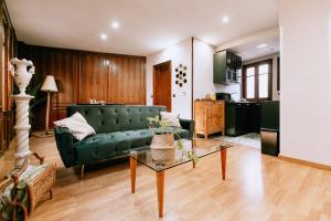 a living room with a green couch and a table at Capricho de Vidania in Huesca