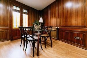 a dining room with wooden walls and a table and chairs at Capricho de Vidania in Huesca