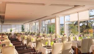 a banquet hall with white tables and chairs and windows at Apartman Smokovec in Smokovce
