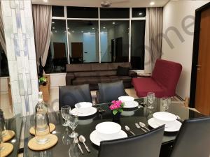 a dining room with a table and chairs and a couch at KLCC Service suites by Home Sweet Home in Kuala Lumpur