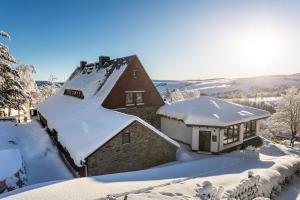 een huis bedekt met sneeuw in de sneeuw bij Ferienhaus Freitag in Kurort Oberwiesenthal