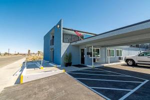 a building with a car parked in front of it at Motel 6 Ridgecrest, CA China Lake in Ridgecrest