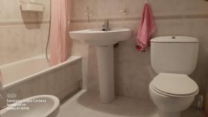 y baño con aseo blanco y lavamanos. en Apartamentos Virita Coqueto Apartamento vacacional, próximo a la playa en A Coruña