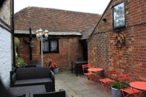 an outdoor patio with red tables and chairs at Anglebury House in Wareham