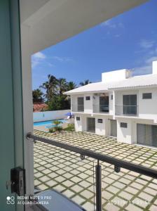 a view of the pool from the balcony of a house at Confortável Duplex a 100 Metros da Praia in Porto Seguro