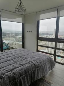 a bedroom with a bed and a view of a city at Reñaca - Eluchans Plaza in Viña del Mar