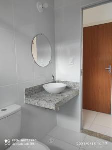 a bathroom with a white sink and a mirror at Confortável Duplex a 100 Metros da Praia in Porto Seguro