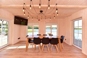 a dining room with a wooden table and chairs at Namelis ant vandens "Giliaus namelis" in Tytuvėnai