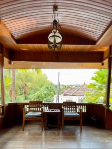 um alpendre com cadeiras, uma mesa e um lustre em Tomohon Private Pool Villa Batu em Malang