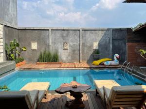 uma piscina com mesa e cadeiras e uma piscina em Tomohon Private Pool Villa Batu em Malang