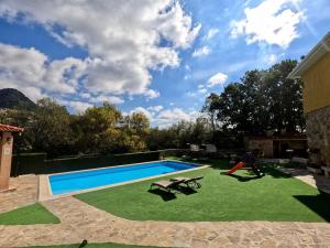 a backyard with a swimming pool and green grass at El huertar de Valentín in Valdemanco