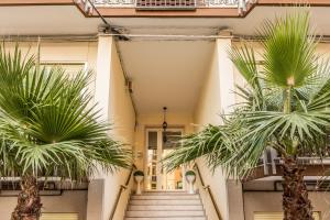 a hallway with palm trees in front of a building at Casa Bellemo in Chioggia
