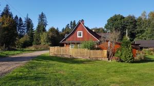 a red house with a fence next to a road at Chalupa u lesa in Červená Voda