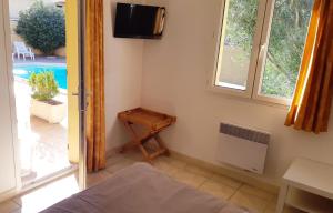 1 dormitorio con 1 cama y TV en la pared en Chambre privée avec Piscine en Marsella