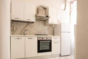 a white kitchen with white cabinets and an oven at Casa Bellemo in Chioggia