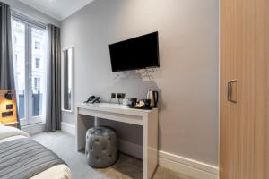 a bedroom with a television and a bed at Gainsborough Hotel in London