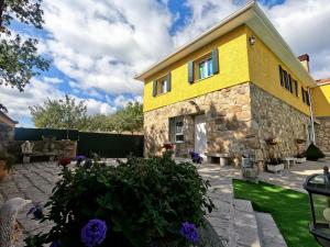 a yellow house with a garden in front of it at El huertar de Valentín in Valdemanco