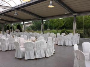 un salón de banquetes con mesas y sillas blancas en Arta Palace en Árta