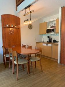een keuken en eetkamer met een houten tafel en stoelen bij Appartement 2 chambres en duplex à La Mongie in La Mongie