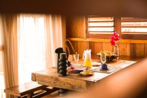 a wooden table with a drink and juice on it at Vila Beijú BARRINHA - Frente Mar! in Barrinha