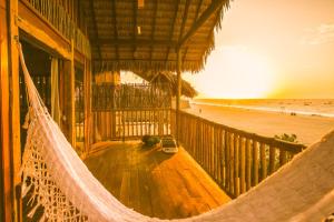 a hammock on a porch of a beach house at Vila Beijú BARRINHA - Frente Mar! in Barrinha