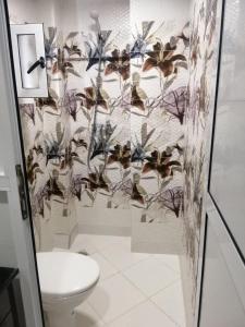 a bathroom with a toilet and a wall with butterflies at Sidi Youssef Agadir in Agadir