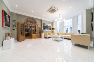 a large room with a lobby with a couch and tables at Gainsborough Hotel in London