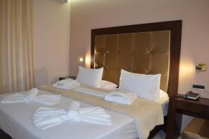 a hotel room with two beds and two lamps at Ellinis Hotel in Chania