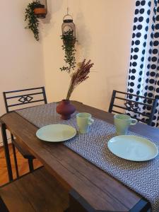 Moti Apartments في كراكوف: طاولة خشبية عليها صحنين و مزهرية +4 صور