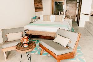 1 dormitorio con 1 cama, 2 sillas y mesa en Hotel B Unique, en Cozumel