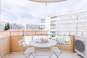 a balcony with a white table and chairs on a building at SERRENDY 3 min from the center & the Croisette in Cannes