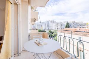 a white table on a balcony with a view at SERRENDY 3 min from the center & the Croisette in Cannes