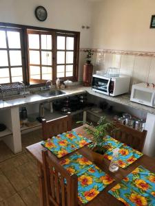 a kitchen with a table with chairs and a microwave at Bela Vista - Casa inteira in Tiradentes