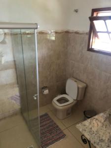 a bathroom with a toilet and a glass shower at Bela Vista - Casa inteira in Tiradentes
