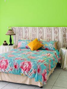 Cama en habitación con pared verde en Direct Access to the Beach, en Port Edward