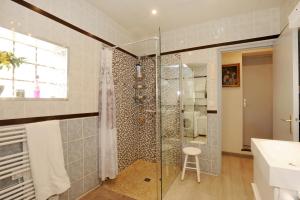 uma casa de banho com uma cabina de duche em vidro e um banco em Pavillon Clara Flor em Prades