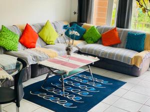 a living room with a couch with colorful pillows at Direct Access to the Beach in Port Edward