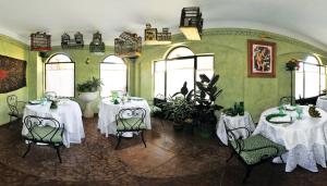 a dining room with two tables and chairs and windows at Albergo Locanda Mezzosoldo in Mortaso
