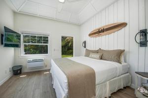 Un dormitorio con una cama y una tabla de surf en la pared. en Casey Key Resorts - Beachfront, en Venice 71 fotos más