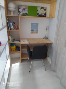 een bureau met een stoel naast een boekenplank bij le studio de la plage in Trouville-sur-Mer