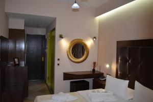 a bedroom with a bed and a mirror on the wall at Ellinis Hotel in Chania